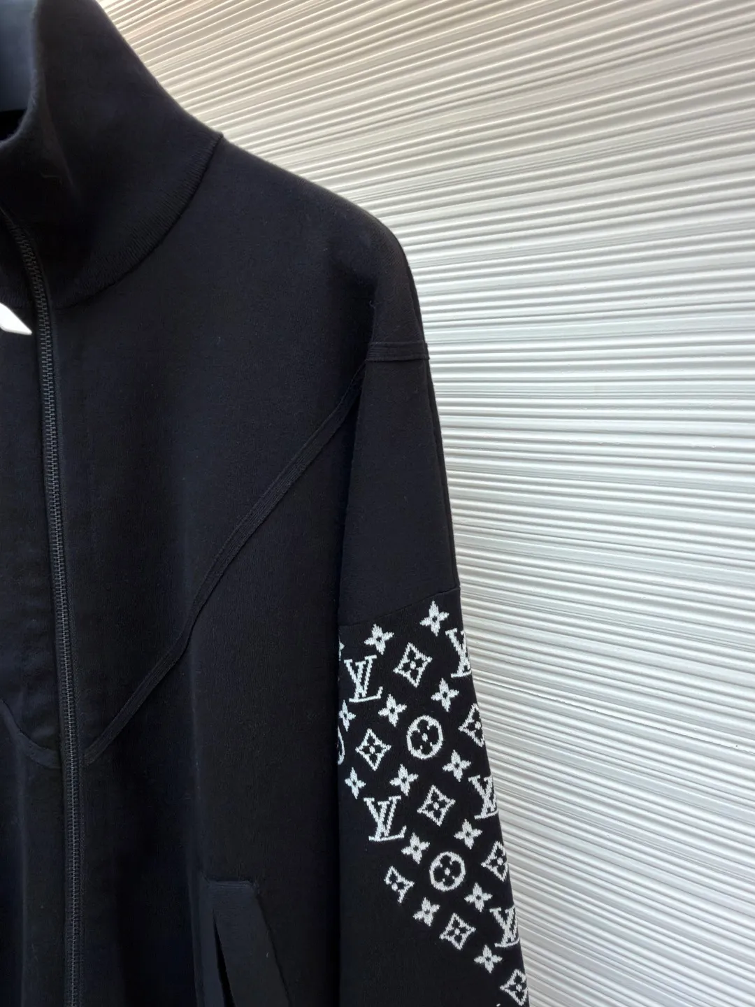 LOUIS VUITTON Monogram element knitted zipper jacket ●Original version: 33000 purchased and developed ●Item number: 1681591-C80 ●Fabric: cotton fabric ●Technology: knitted ●Color: black ●Version: Fitted version ●Weight: about 605 grams ●Size: S-M-L-XL ●Description: This black jacket is made of high-density cotton blended fabric, which feels thick and crisp, and is both soft and wear-resistant. The stand-up collar design and metal zipper are both warm and neat. The classic presbyopia pattern on the sleeves uses fine jacquard technology, and the pattern is three-dimensional and clear, highlighting brand recognition. The body is designed for a loose fit and has a smooth cut for comfort and freedom of movement. There are large pockets on both sides of the front placket, taking into account both practicality and decoration. The inside of the collar and cuffs are double-line reinforced to enhance durability. The brand logo on the chest uses precision embossing technology, and the surface is multi-layered to give it a uniform luster, which contrasts sharply with the black fabric. The inside is neatly hemmed with no excess threads, reflecting the exquisite sewing craftsmanship. The overall design is simple and elegant, with exquisite details. From fabric selection to hardware accessories, every aspect reflects the pursuit of quality. It is an ideal choice for daily wear and outdoor travel. The overall wiring is straight and delicate, the fabric is comfortable and soft, and the color is consistent without color difference. It can be matched with the same style to create a fashionable look and control various occasions. Customized accessories, complete with three standards, same style for men and women!